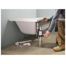 Eine Person verwendet einen Stanley TradeLift, um eine weiße Badewanne während der Installation zu nivellieren.