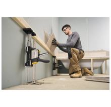 Ein Handwerker nutzt einen Stanley Trade Lift zur Abstützung eines Holzbalkens bei der Fliesenverlegung im Badezimmer während der Renovierung.