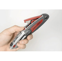 Hand hält ein Rautner Cuttermesser mit geöffnetem Klingenmagazin.