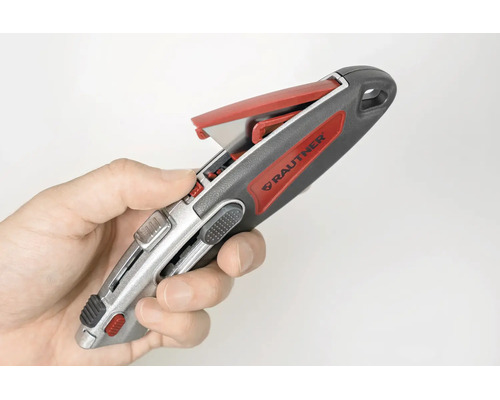 Hand hält ein Rautner Cuttermesser mit geöffnetem Klingenmagazin.