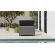 Offene graue Gartenbox aus Metall mit Rollen und Holzgriff auf einer hellen Terrasse neben einem Pool.