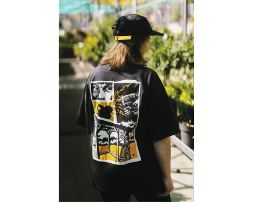 Schwarzes T-Shirt mit großflächigem Comic-Grafikdruck auf dem Rücken, der Werkzeuge und Bauszenen darstellt.