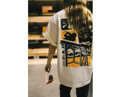Rückansicht einer Person in einem weißen T-Shirt mit Grafikdruck, der verschiedene Heimwerker-Szenen und Werkzeuge zeigt.