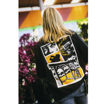 Rückansicht einer Person mit einem schwarzen T-Shirt mit grafischem Heimwerker-Print im Comic-Stil, der eine Bohrmaschine und ein Holzbauprojekt zeigt.