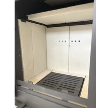 Brennraum eines Kaminofens mit Schamotteauskleidung und gusseisernem Rost