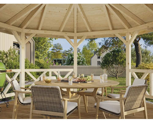 Achtkantiger Holzpavillon mit offener Dachkonstruktion, Kreuzgeländer und Gartenset aus Holz mit geflochtenen Sesseln und hellen Auflagen.
