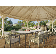 Offener Holzpavillon mit Gartentisch und geflochtenen Sesseln auf einer Holzterrasse in einem begrünten Garten.