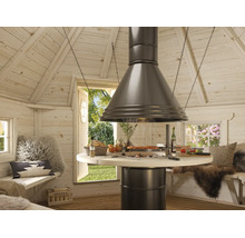 Innenansicht einer hellen Grillkote aus Holz mit zentralem runden Grilltisch, einer großen Abzugshaube aus Metall und Sitzbänken mit Kissen.