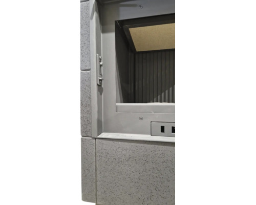 Detailansicht eines Kaminofeneinsatzes mit Metallrahmen und strukturierten Fliesen.