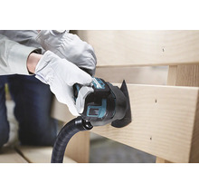 Eine Person mit weißen Arbeitshandschuhen schneidet mit einem Makita Multifunktionswerkzeug mit Sägeblatt und Staubabsaugung eine Holzplanke.
