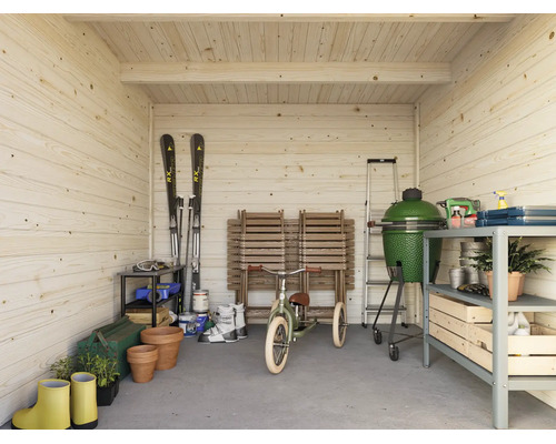 Innenansicht eines Gartenhauses aus hellem Holz, ausgestattet mit Regalen, Grill, Skiern, Kinderdreirad und Gartenutensilien.