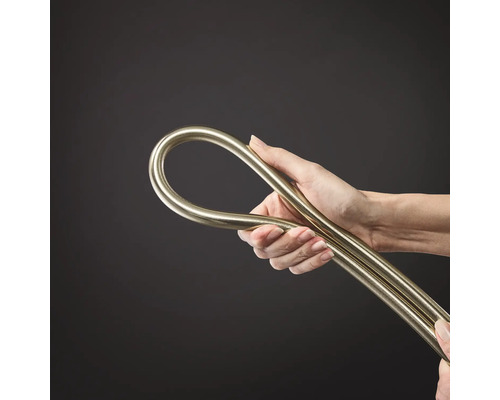 Hand hält einen flexiblen metallischen Installationsschlauch oder ein biegsames Metallrohr.