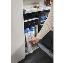 Eine Hand wechselt eine Blanco Sodakartusche im Blanco Wassersystem unter der Küchenspüle.