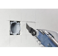 Multifunktionswerkzeug schneidet Ausschnitt für eine Unterputzdose in eine Trockenbauwand.