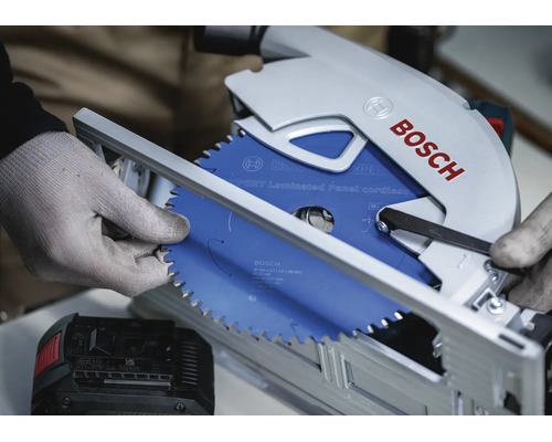 Eine Bosch Akku Handkreissäge mit einem Expert Laminated Panel Kreissägeblatt wird von einer Person mit Arbeitshandschuhen montiert.