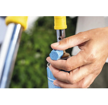 Hand bedient das Regulierventil einer Gasflasche fuer einen Abflammgeraetaufsatz