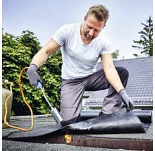 Handwerker beim Verschweißen von Bitumenschweißbahnen mit einem Gasbrenner auf einem Flachdach.