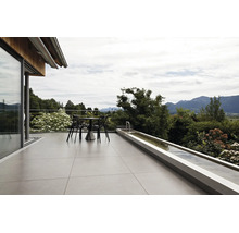 Moderne Terrasse mit großen Bodenfliesen, Sitzgruppe und einem langgestreckten Wasserbecken mit Blick auf die Alpen.