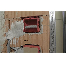Unterputzdosen in einer Ziegelwand mit Leerrohren für die Elektroinstallation bei einem Neubau oder einer Renovierung.
