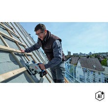 Handwerker mit Bosch Akku Handkreissäge bei der Montage von Dachlatten auf einer Baustelle unter freiem Himmel. (Image AI modified or generated)
