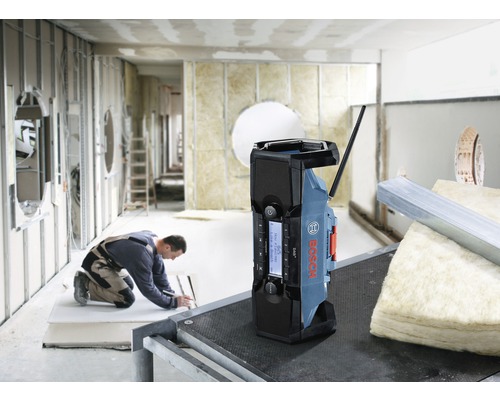 Baustellenradio von Bosch auf einer Baustelle, ein Arbeiter im Hintergrund.