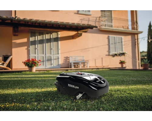Schwarzer Rasenmähroboter Tech L20 auf Rasen vor einem Haus