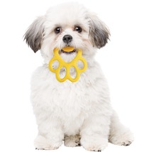 Ein weißer Hund hält einen gelben Pfotenabdruck-Beißring im Maul.
