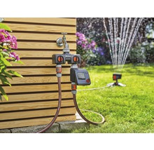 Gardena Wasserverteiler automatic mit zwei Ausgängen und Bewässerungscomputer im Einsatz im Garten.