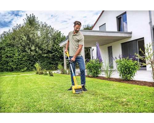Ein Mann benutzt einen Rasenkanten-Reiniger im Garten.