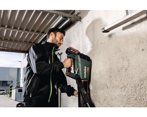 Ein Mann verwendet ein Metabo Ortungsgerät an einer Wand.