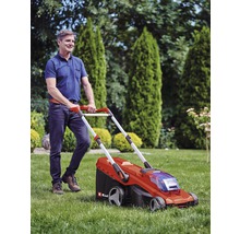 Ein Mann bedient einen Rasenmäher im Garten.