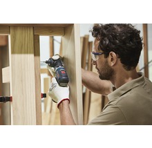 Ein Handwerker arbeitet mit einem Winkelbohrschrauber an einem Holzrahmen.