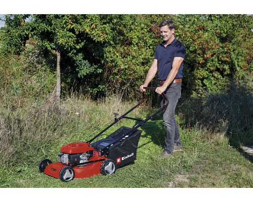 Mann bedient einen Einhell Benzin-Rasenmäher im Garten.