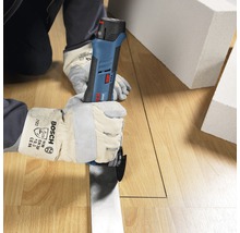 Person schneidet mit einem Bosch Multifunktionswerkzeug einen Laminatboden.