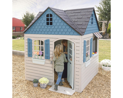 Spielhaus mit Fenstern, Tür und Kindern im Garten