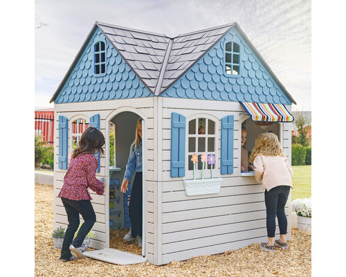 Spielhaus mit Fenstern, Tür und Kindern im Garten