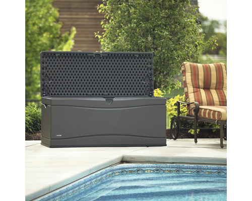 Geöffnete, graue Gartenbox aus Kunststoff neben Pool und Sessel