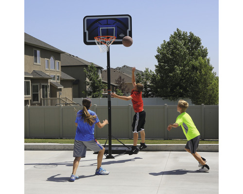Szene mit Kindern, die auf einem Basketballplatz mit einem Basketballkorb spielen
