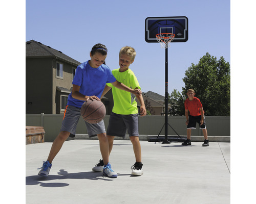 Kinder spielen Basketball auf einem Basketballkorb im Freien