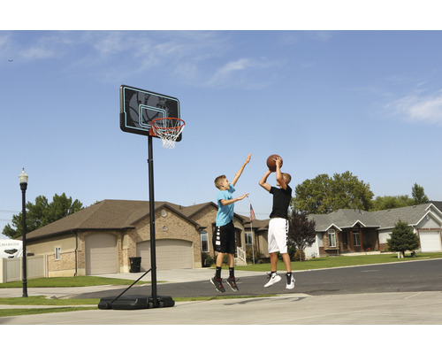 Freistehender Basketballkorb mit zwei spielenden Jungen im Wohngebiet