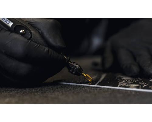 Nahaufnahme einer Person, die mit einem Dremel Schleifarbeiten durchführt