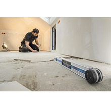 Ein Handwerker arbeitet mit einem digitalen Neigungsmesser von Bosch in einem Raum.