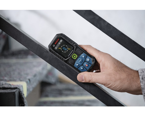 Hand hält digitales Neigungsmeßgerät von Bosch an einem Geländer