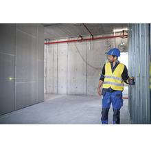 Handwerker verwendet einen Linienlaser zur Ausrichtung von Metallständerwerk im Rohbau