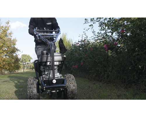 Person bedient Motorhacke im Garten.