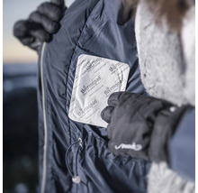 Person legt Wärmepflaster in eine Jackentasche