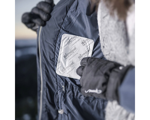 Person legt Wärmepflaster in eine Jackentasche