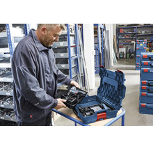 Ein Mann packt einen Akku-Bohrschrauber in einen Werkzeugkoffer.