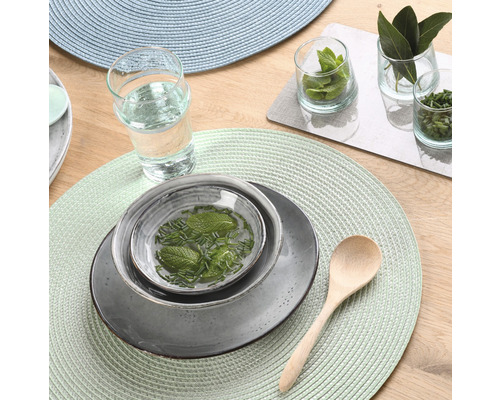 Tischdekoration mit Tellern, Schalen, Gläsern, Holzlöffel und runden Tischsets