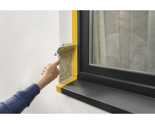 Verputzen einer Wand neben einem Fenster mit Abdeckband zum Schutz